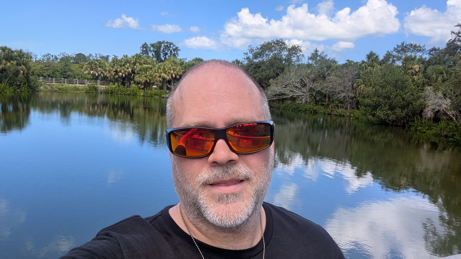Joel in Michigan, standing by the water on a sunny day